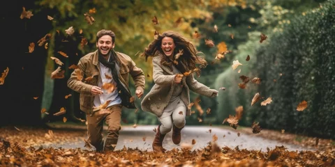 Poster Im Rahmen couple walking in autumn park.autumn wind flying leaves © Daunhijauxx