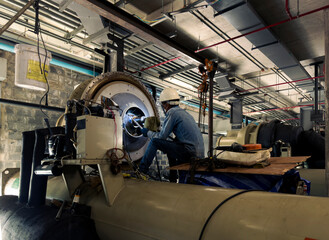 Fototapeta premium maintenance service engineer or an employee at the industrial compressor chiller room station Repair and adjust equipment in production plants.