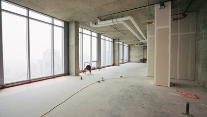 Push in shot of an empty penthouse under construction, showcasing the spacious interior and potential design