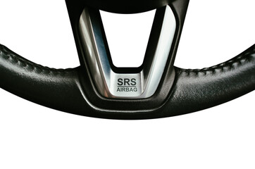 SRS Supplemental Restraint System Airbag symbol on leather steering wheel of a car, close up of SRS Airbag banner with silver colour on white background, Automotive parts concept