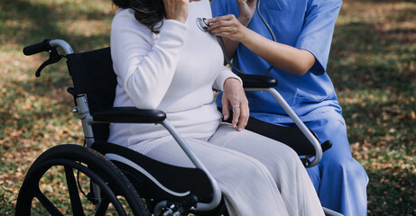 Asian young woman nurse at nursing home take care disabled senior man. Caregiver doctor serve physical therapy for older elderly patient to exercise and practice walking on walker or cane at backyard.