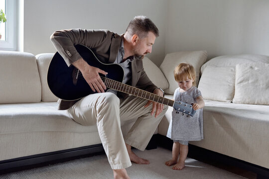 Naklejki Curious little girl and father with guitar