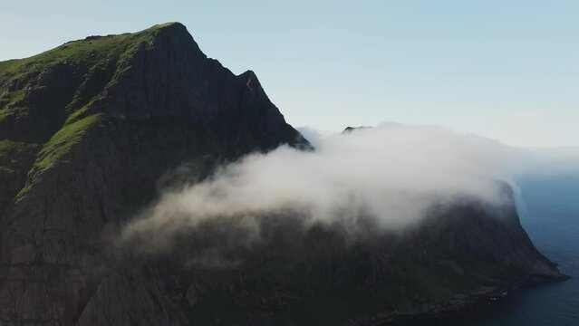 Cinematic drone shot of clouds moving over cliffs at Horseid Beach.  Northern side of Moskenes&oslash;y, in the western part of Lofoten