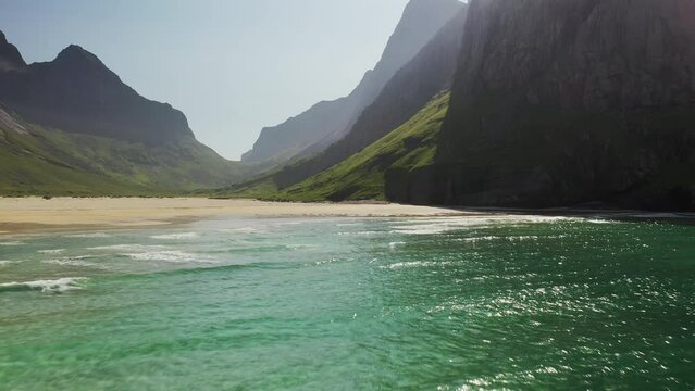 Cinematic drone shot at Horseid Beach flying over turquoise blue water.  Northern side of Moskenes&oslash;y, in the western part of Lofoten