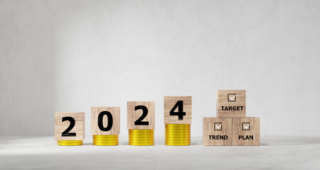 2024 Action Plan. Cubes with text 2024 and target, trend, and plan on coins stack. Business development to success and growing growth strategy, investment, financial.