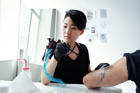 Artist looking at tattoo machine