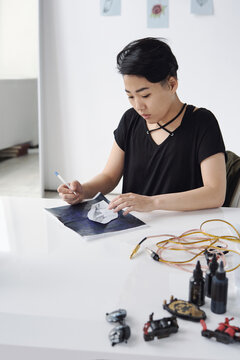 Tattoo master outlining sketch on transfer paper