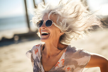 portrait of happy dancing mature retired woman at the beach enjoying retirement