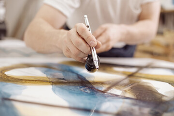 Closeup of man using airbrush while painting