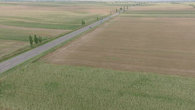 Vehicles Driving On European Route 85 Through Fields In Romania. aerial