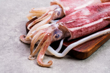 Close-up shot of fresh raw octopus on a wooden cutting board background. seafood squid top view