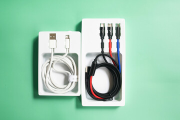 Folded USB lightning cable isolated over the green background. Three types of peripheral connections and charging or data cables.