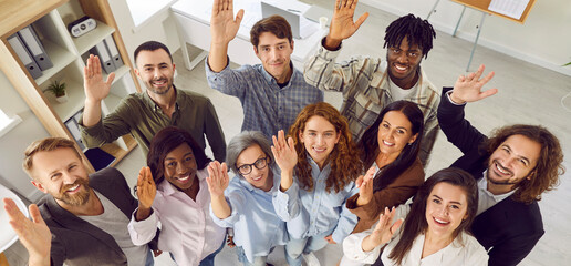 Top view of a group of diverse happy business people men and women looking at the camera, smiling...