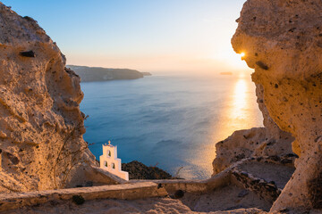 Church of Agios Nikolaos in Santorini island, Greece. View of the sea and rocks at sunset.