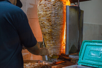 Meat trompo for tacos al pastor. Mexican street food. Marinated meat al pastor.