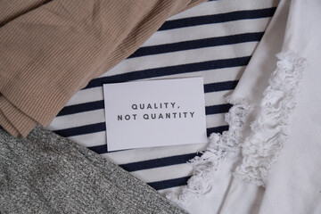 Quality not quantity text on paper note on clothes assortment Second hand sustainable shopping....