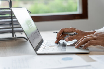 Man working by using a laptop computer Hands typing on keyboard. writing a blog. Working at home are in hand finger typewriter