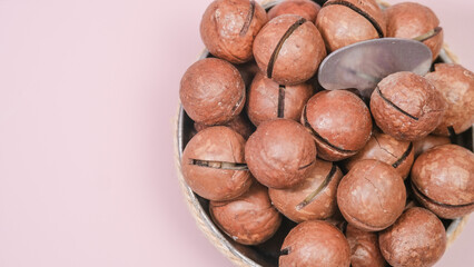 a dish with macadamia nuts. view from above. Organic macadamia nut on a pink background - a close-up of a natural macadamia nut on a light background is a copy space for business. Useful product