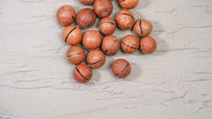 Close-up of macadamia nuts on a gray tree background, the concept of superfoods and healthy nutrition, a picture from above, a copy space for business