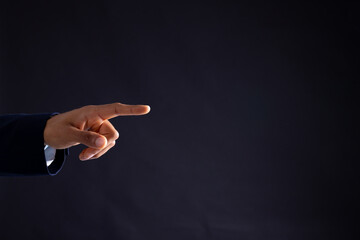 Hand of biracial businessman pointing with copy space on black background