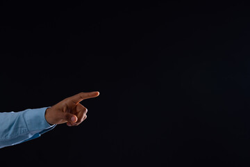 Hand of biracial businessman pointing with copy space on black background