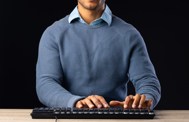 Biracial businessman using keyboard with copy space on black background