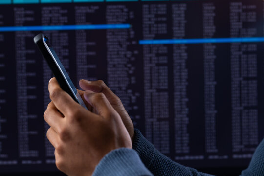 Biracial businessman using smartphone and data processing on grey background