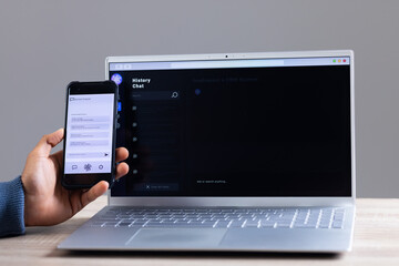 Biracial businessman using smartphone and data processing on laptop screen