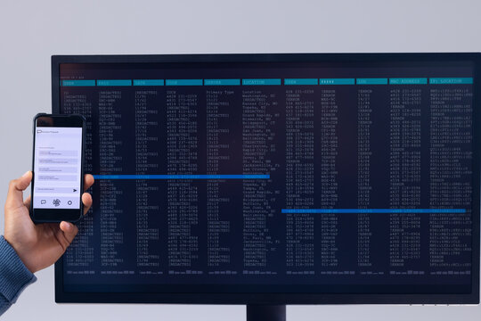Biracial businessman using smartphone and data processing on computer screen
