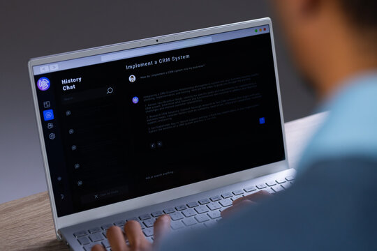 Biracial businessman using laptop and data processing on screen - Powered by Adobe
