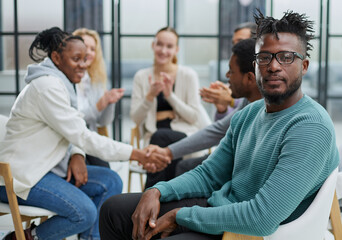 Gathered happy young businessmen holding negotiations, meeting with friendly diverse colleagues