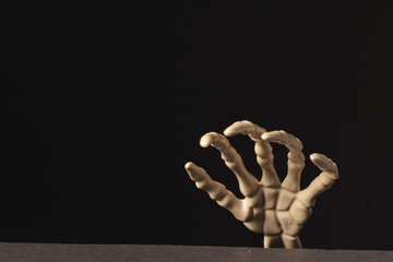 Obraz premium Plastic skeleton hand with copy space on black background