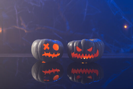 Fototapeta Carved pumpkins with copy space on blue background