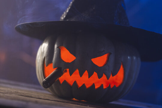 Fototapeta Carved pumpkin wearing witch hat on blue background