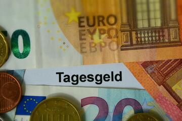 Das Wort Tagesgeld auf Euro Geldscheinen und Münzen