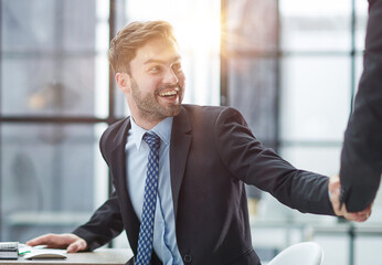 Portrait of cheerful young manager handshake with colleague