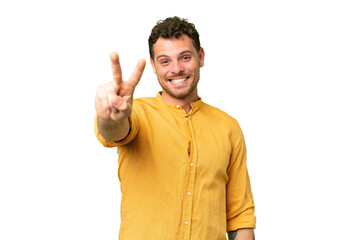 Fototapeta premium Brazilian man over isolated chroma key background smiling and showing victory sign