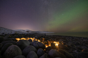 Northern lights over famous stone eggs beach in Teriberka, Murmansk oblast, Russia