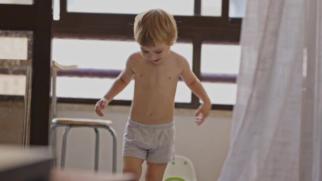 Little boy in underpants having fun and dancing in the kitchen
