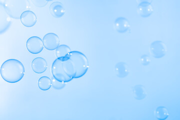 Refreshing of Soap suds, Bubbles Water. Beautiful Transparent Blue Soap Bubbles Floating in The Air. Abstract Blurred Background, Blue Textured, Celebration Festive Backdrop.
