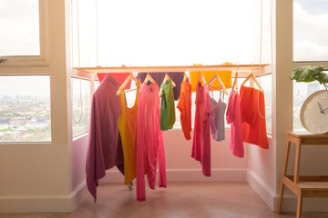 Colorful clothes hanging on the balcony dry in sun at apartment. - Powered by Adobe