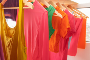 Colorful clothes hanging on the balcony dry in sun at apartment.