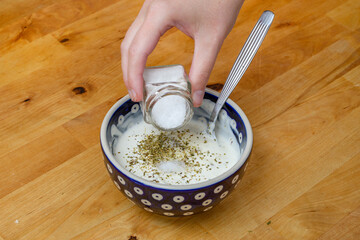 Przyprawiać solić biały sos w miseczce 