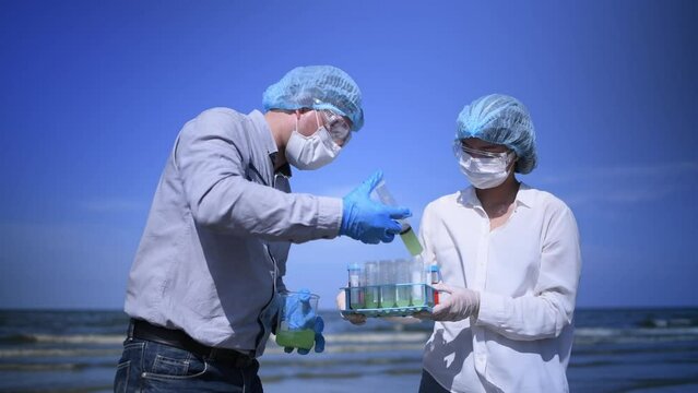 Scientist analysis wearing protective uniform,mask,glove and box under working water analysis effected from phytoplankton at sea ananly case in laboratory is environment pollution problem concept.	