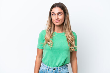 Young Uruguayan woman isolated on white background having doubts while looking side