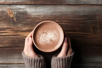  Female hands holding a cup of hot chocolate with cocoa powder on wooden background © ttonaorh