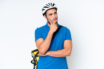 Young caucasian man with thermal backpack isolated on white background having doubts and with confuse face expression