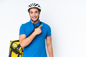 Young caucasian man with thermal backpack isolated on white background pointing to the side to present a product