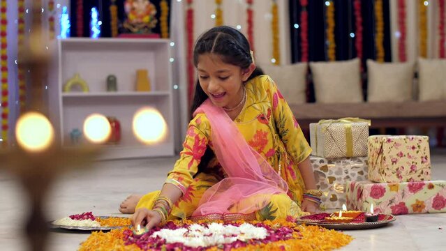 A cute happy girl decorating rangoli with Diya  Colorful house  Diwali festival decoration. Video of a cute Indian girl wearing an Indian dress decorating her home with diya and rangoli  Deepawali ...