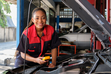 Fototapeta na wymiar One Black female professional automotive mechanical worker checks an EV car battery and hybrid engine at a maintenance garage, expert electric vehicle service, and fixing occupations auto industry.